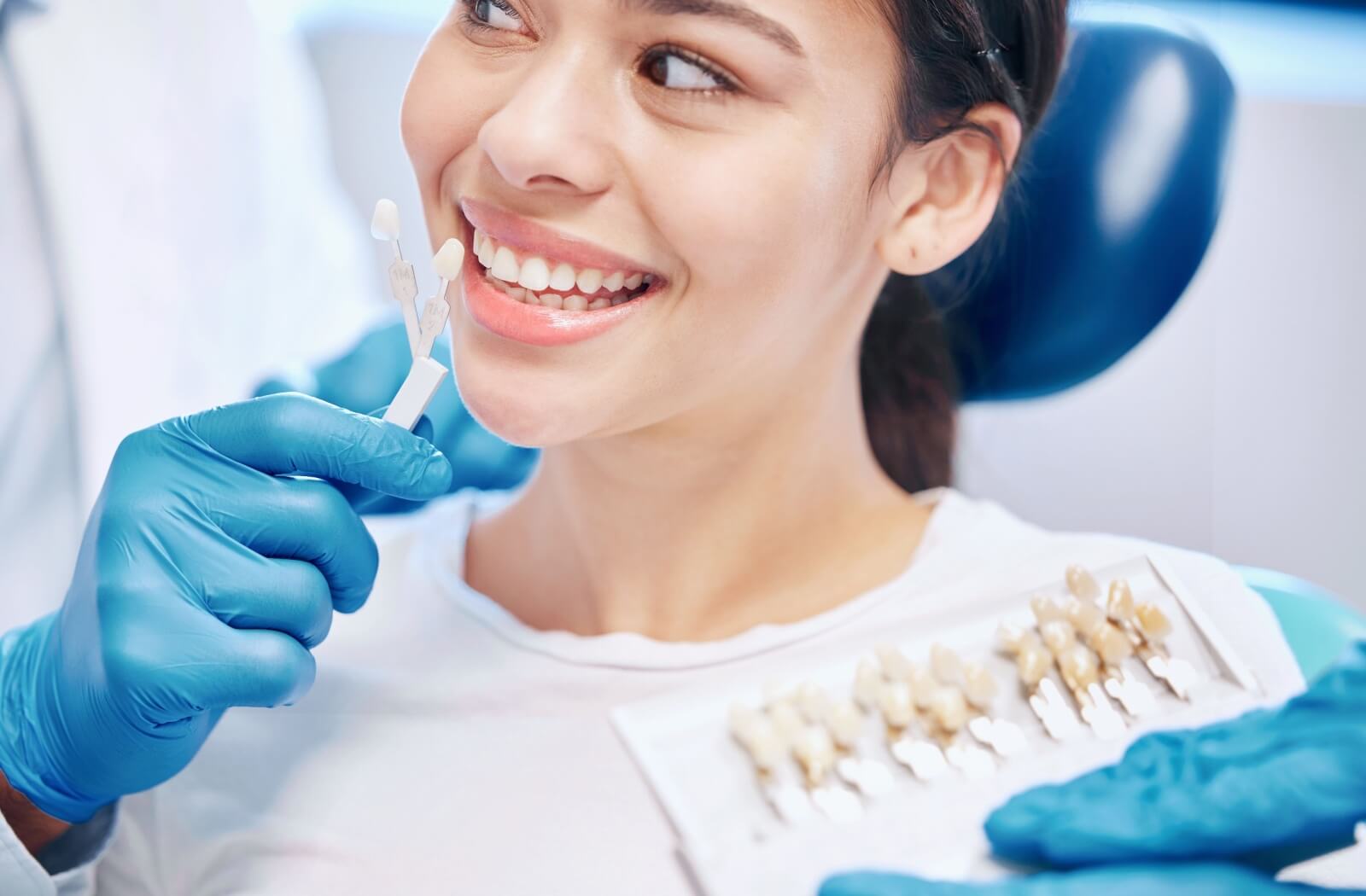 Patient undergoing color matching for dental crowns in Red Deer.