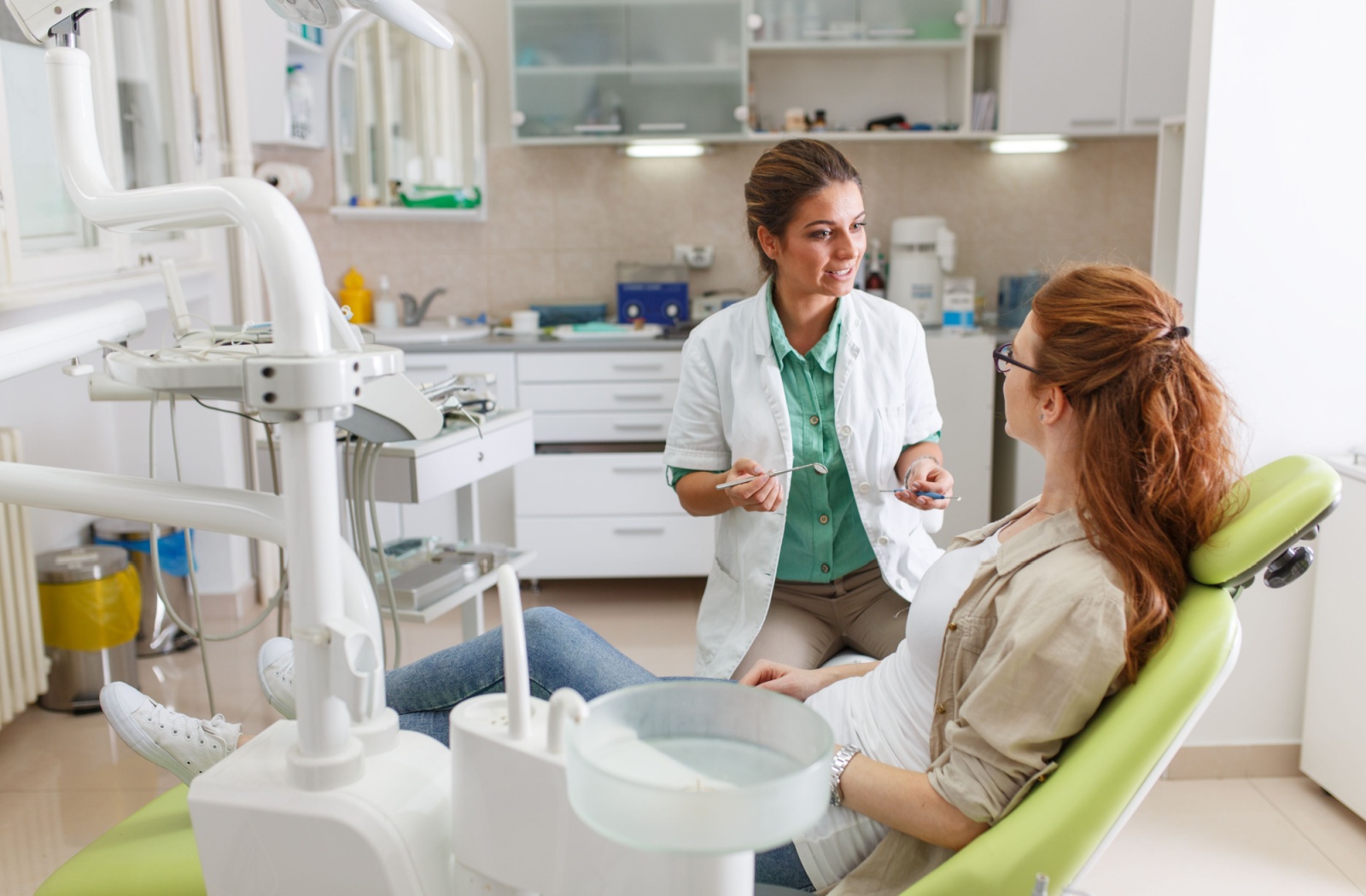 A patient in the dental chair listens to their dentist's aftercare instructions following their tooth extraction.
