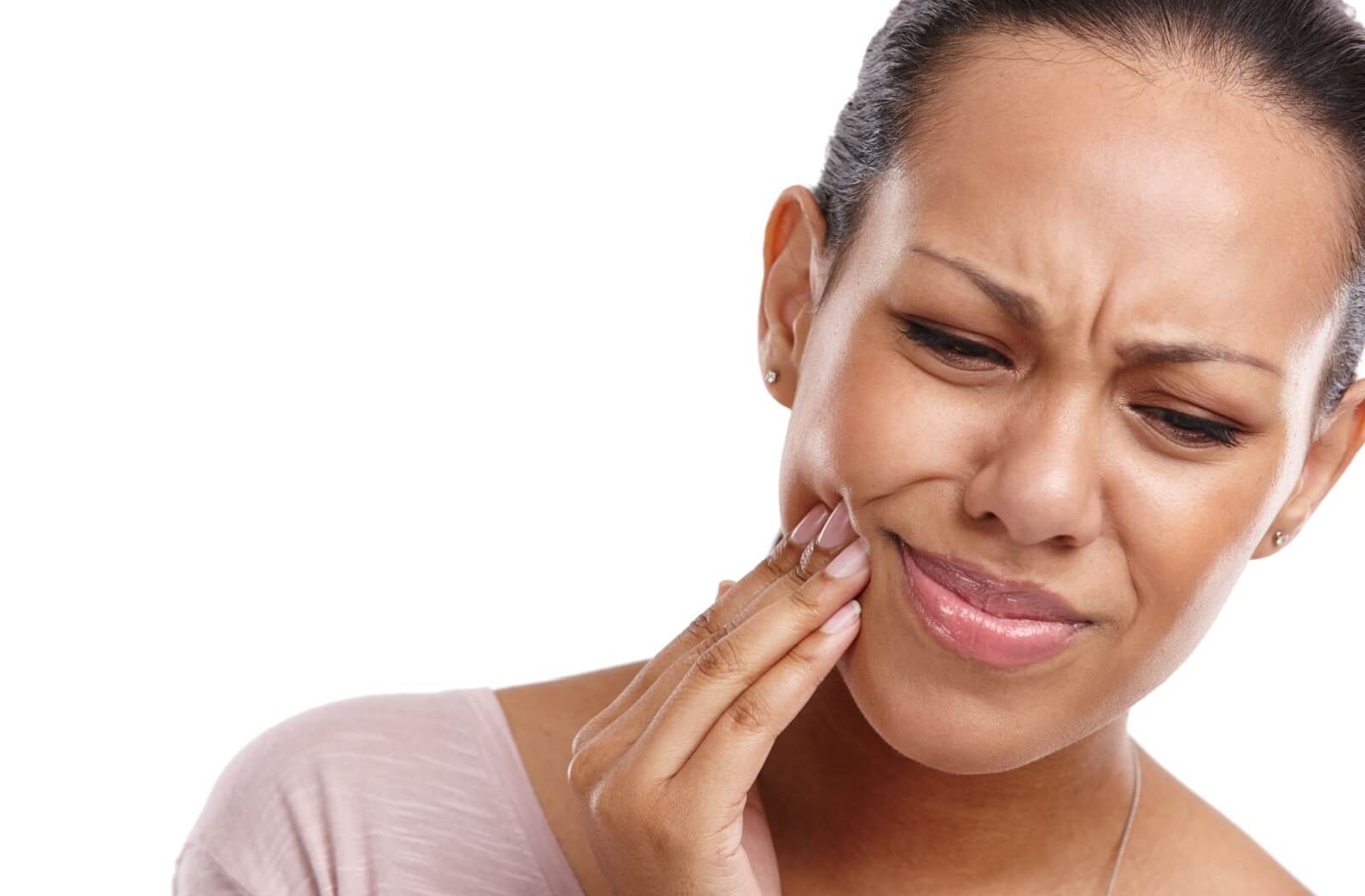 A person who seems to be in pain massages their jaw.