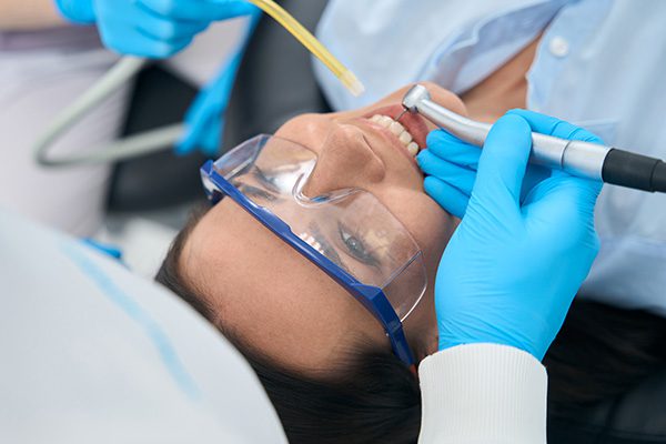 A female patient undergoes root canal therapy in Hamilton, Ontario, attended by a dentist in a professional setting.