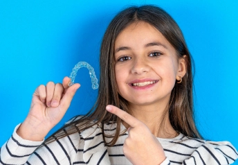 girl holding invisalign